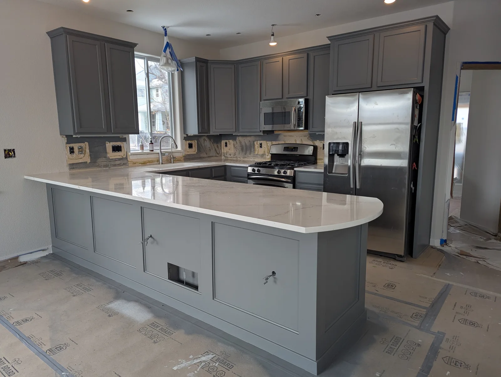 Small kitchen with freshly refinished gray cabinets and a peninsula