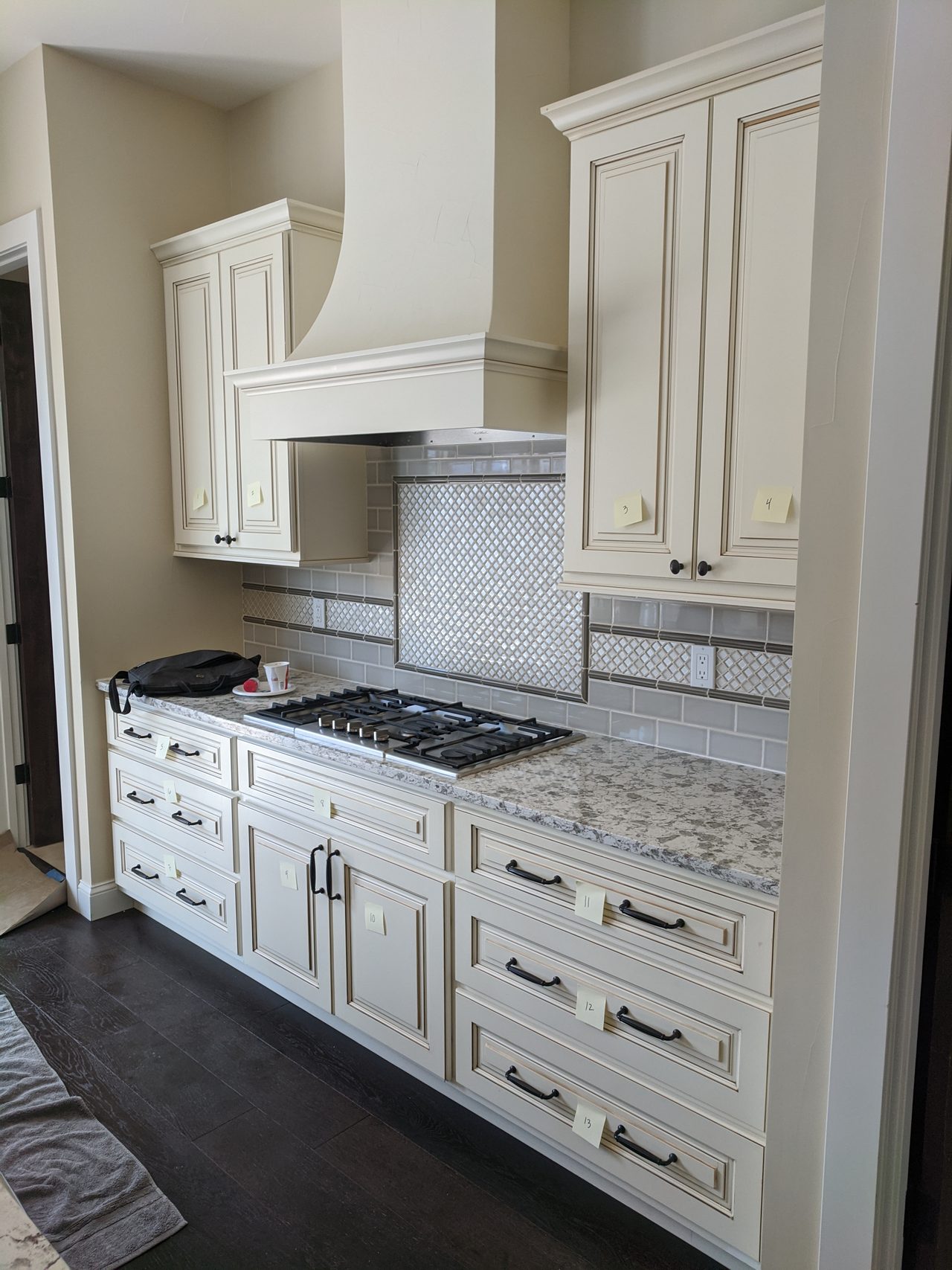 Crisp white kitchen with a custom range hood and marble counters