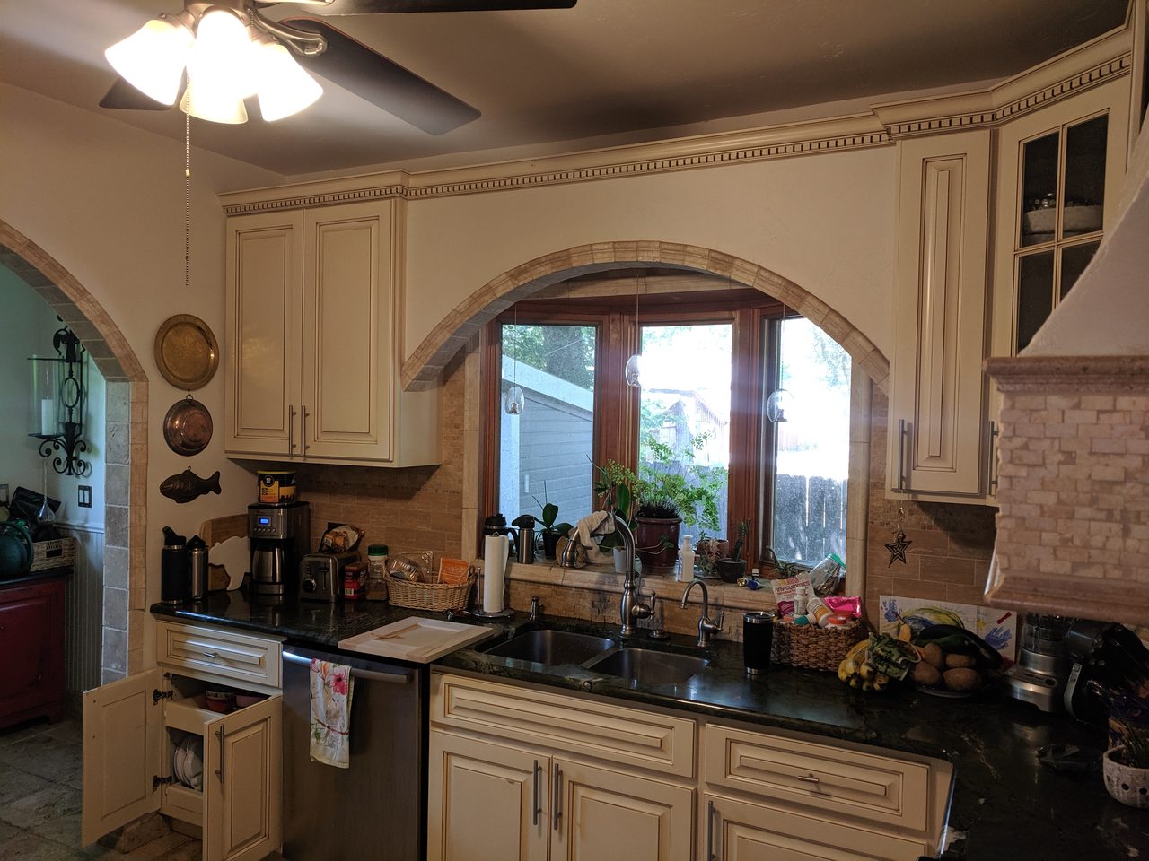 Warm traditional kitchen with refinished cabinetry and an arched window